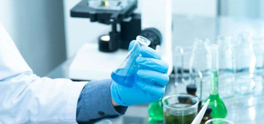 person holding laboratory flask